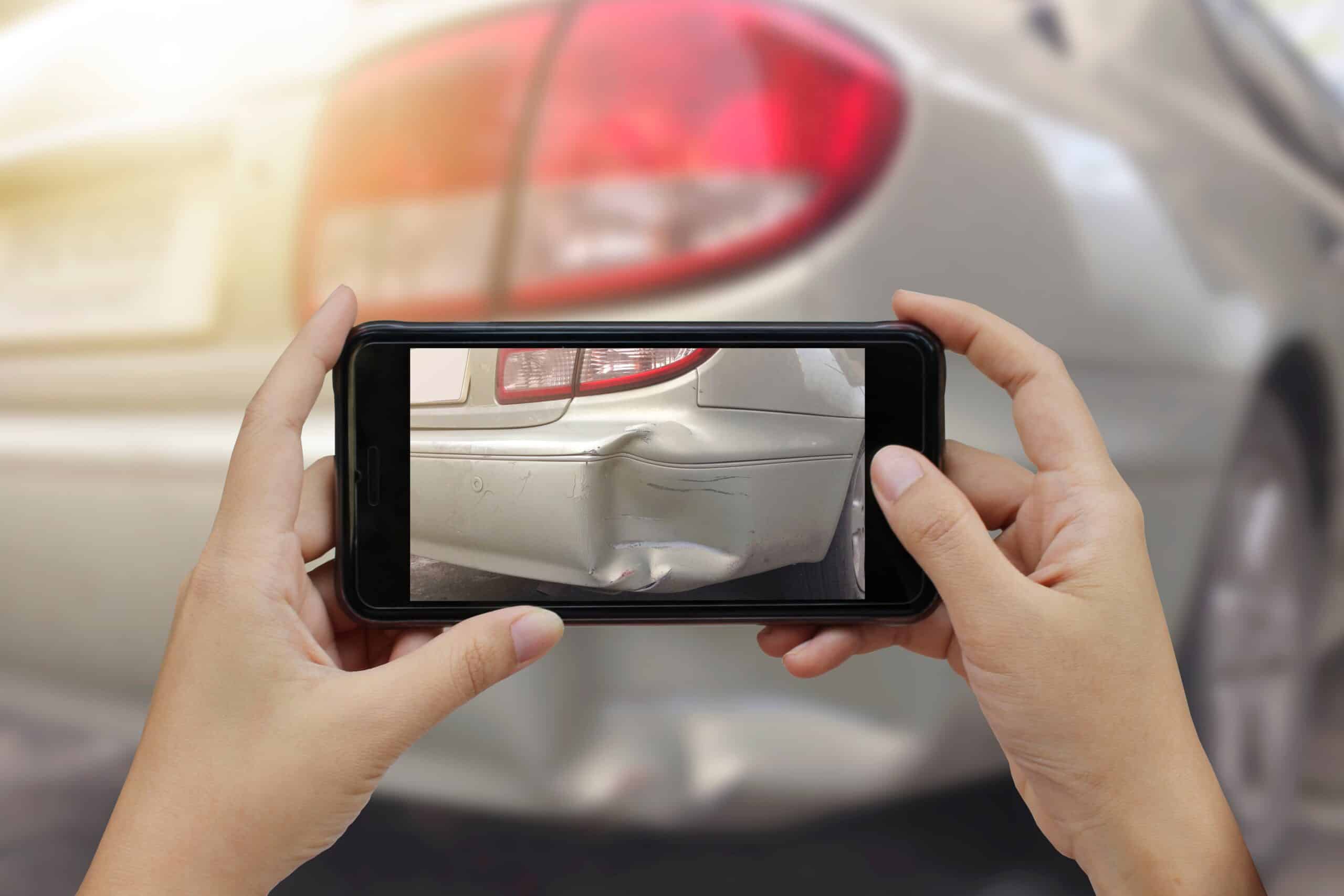 Hand holding smart phone take a photo at The scene of a car crash, car accident for insurance.