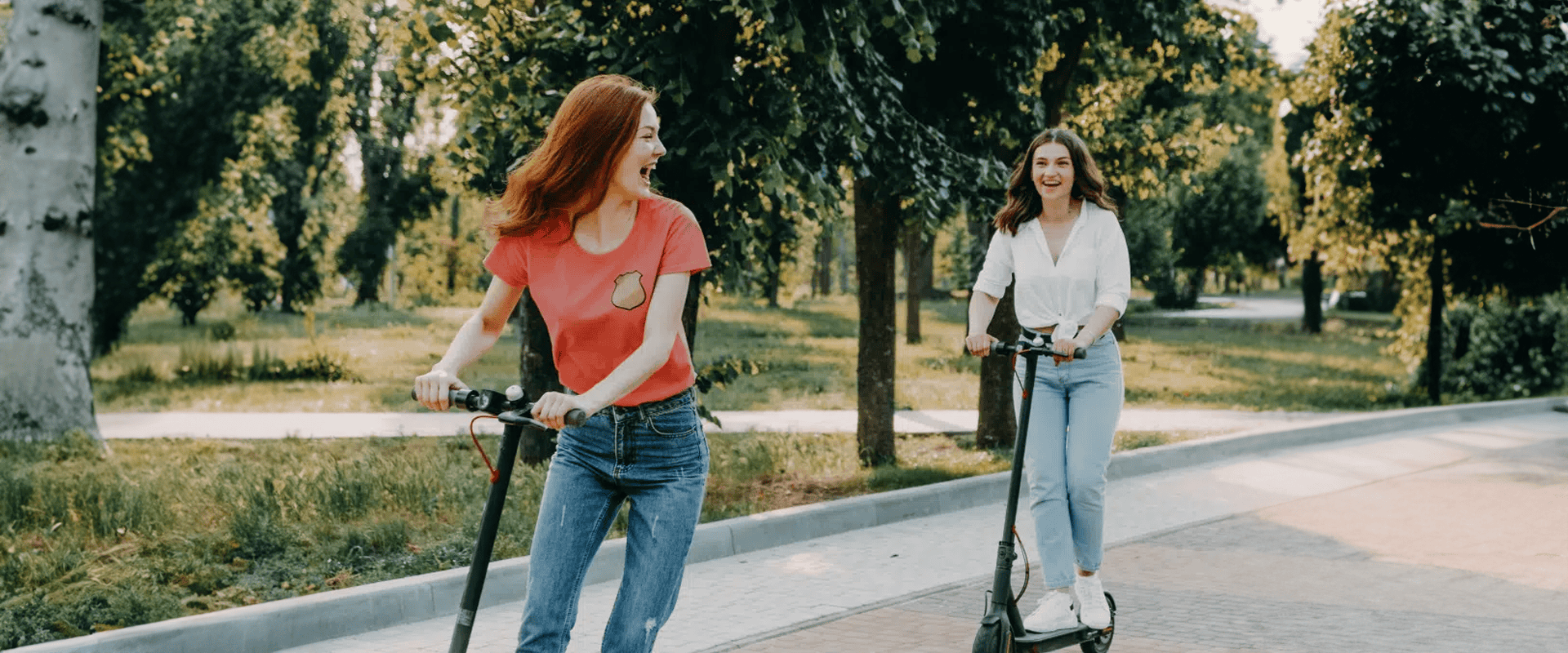two women on scooters on a road